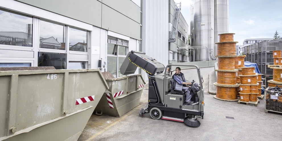 The container of a vacuum sweeper is being emptied