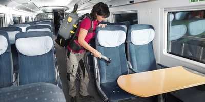 Person cleaning the seats on a train Person cleaning the seats on a train