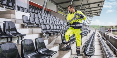 Person cleaning a soccer stadium with a high pressure cleaner