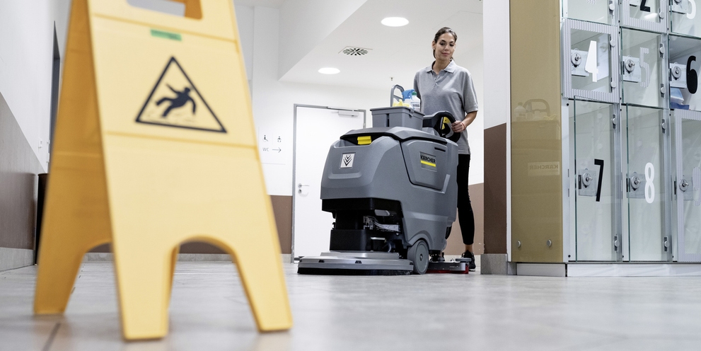 Floor cleaning with the scrubber-dryer A woman operates the scrubber-dryer