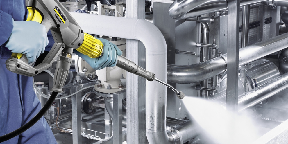 A person operates a stationary high-pressure system