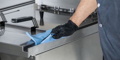 Person claning an oven stove Person claning an oven stove
