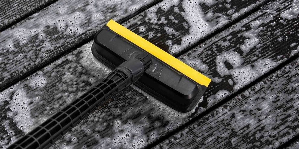 Cleaning wood decking with a power scrubber A Kärcher power scrubber cleans a wooden deck