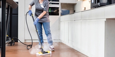 Person cleaning an office kitchen with steam Person cleaning an office kitchen with steam