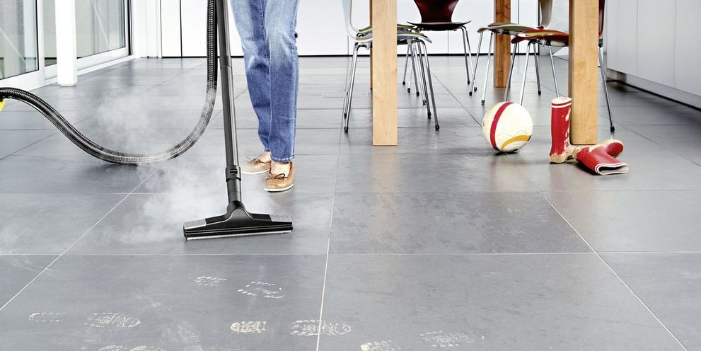 The Kärcher SV 7 hygienically cleans dirty footprints on grey tiled floors with steam.