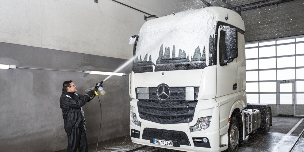 Truck cleaning with cleaning concentrate A person spraying a truck with cleaning concentrate