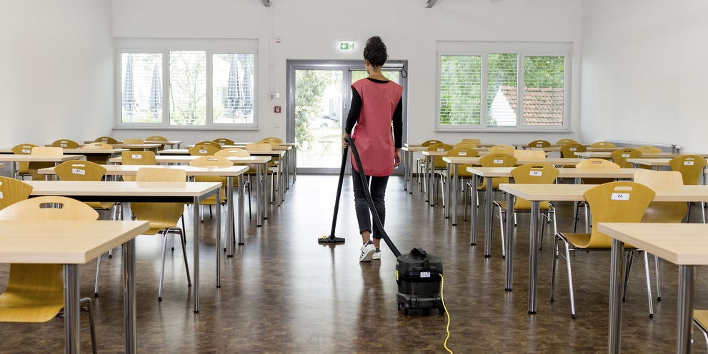 Floor cleaning with a dry vacuum cleaner A person cleaning the floor with a dry vacuum cleaner