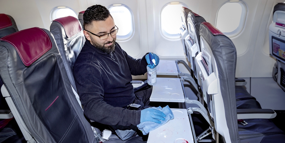 A person cleaning the seating area with a microfiber cloth
