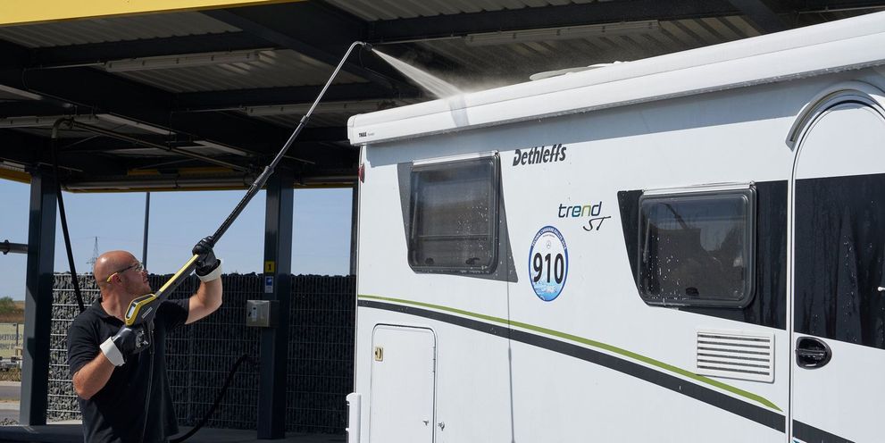 Clean caravan with pressure washer and telescopic jet pipe A man uses a Kärcher telescopic jet pipe to clean the roof of his caravan