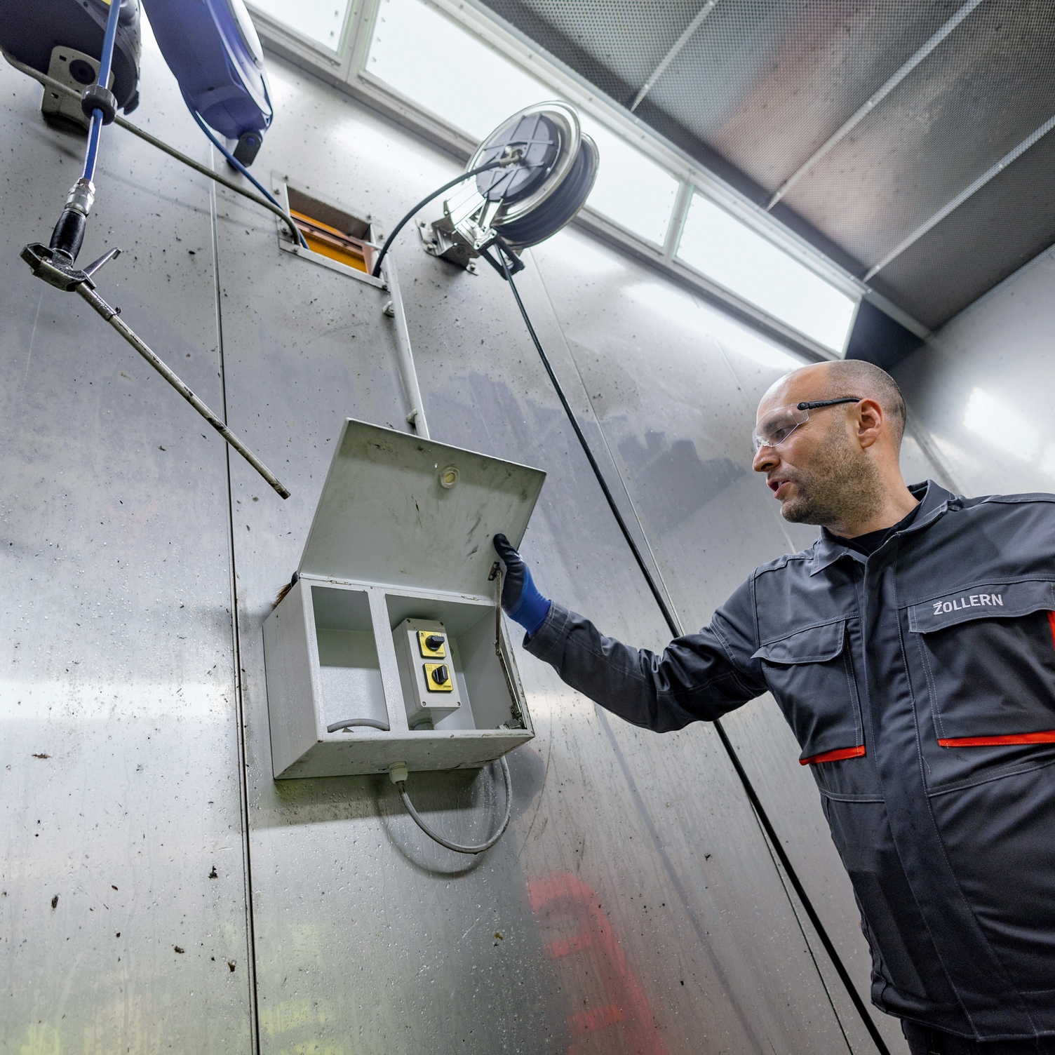 Man opens control box of stationary high-pressure cleaner