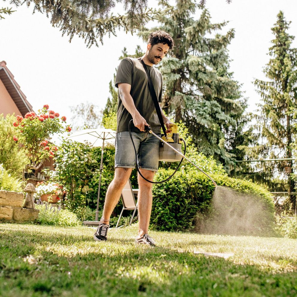 Person removes weeds with the Kärcher cordless pressure sprayer