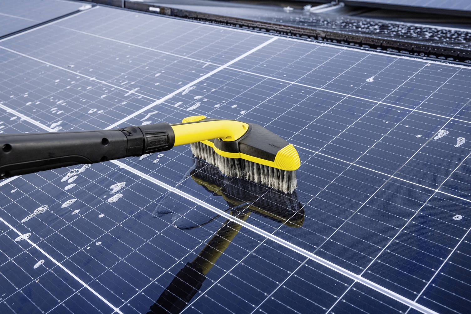 Image shows cleaning of a solar panal using the soft wash brush