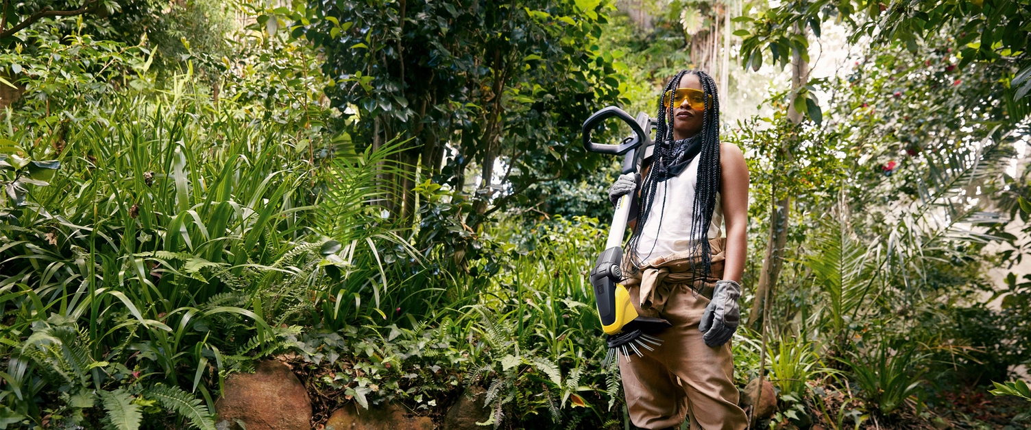 Woman with battery weed remover in the garden