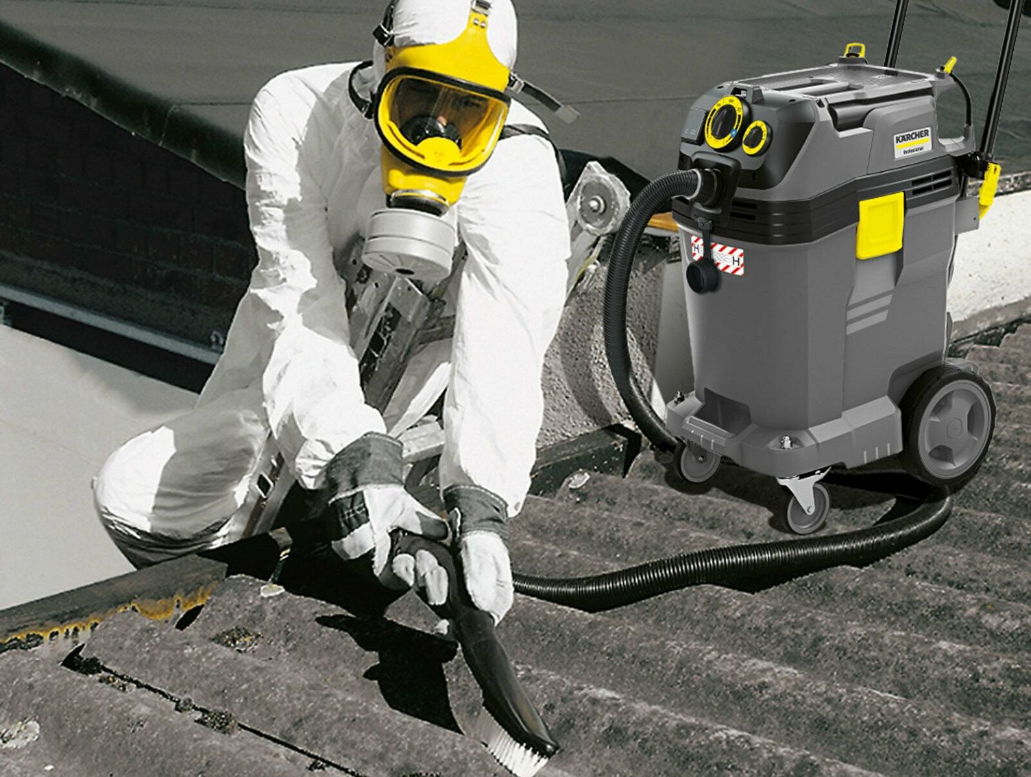 Asbestos removal A person in white protective clothing with a breathing mask cleans residues on a roof with a Kärcher Safety Vacuum Cleaner