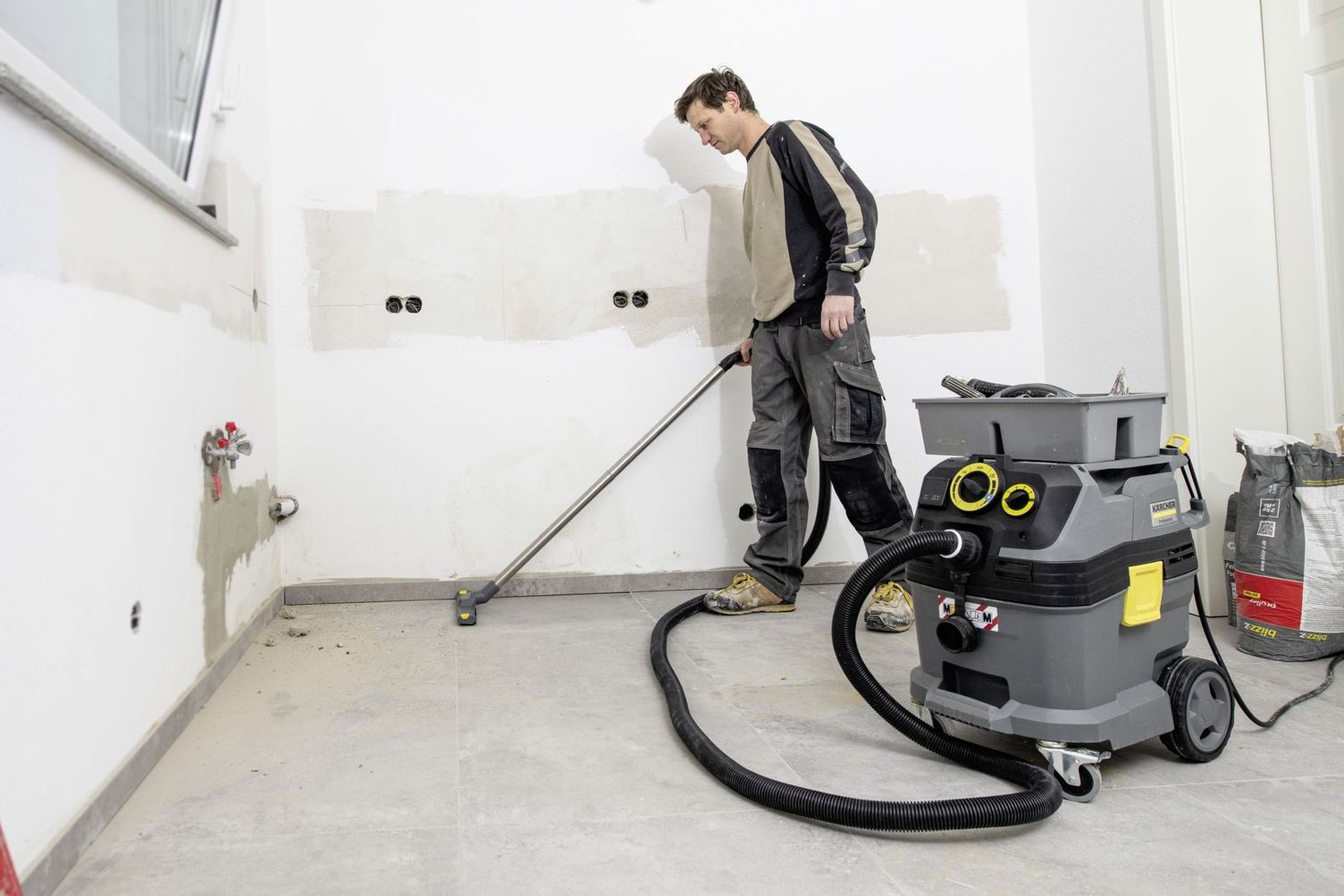 A person removes dust with a Kärcher Vacuum Cleaner