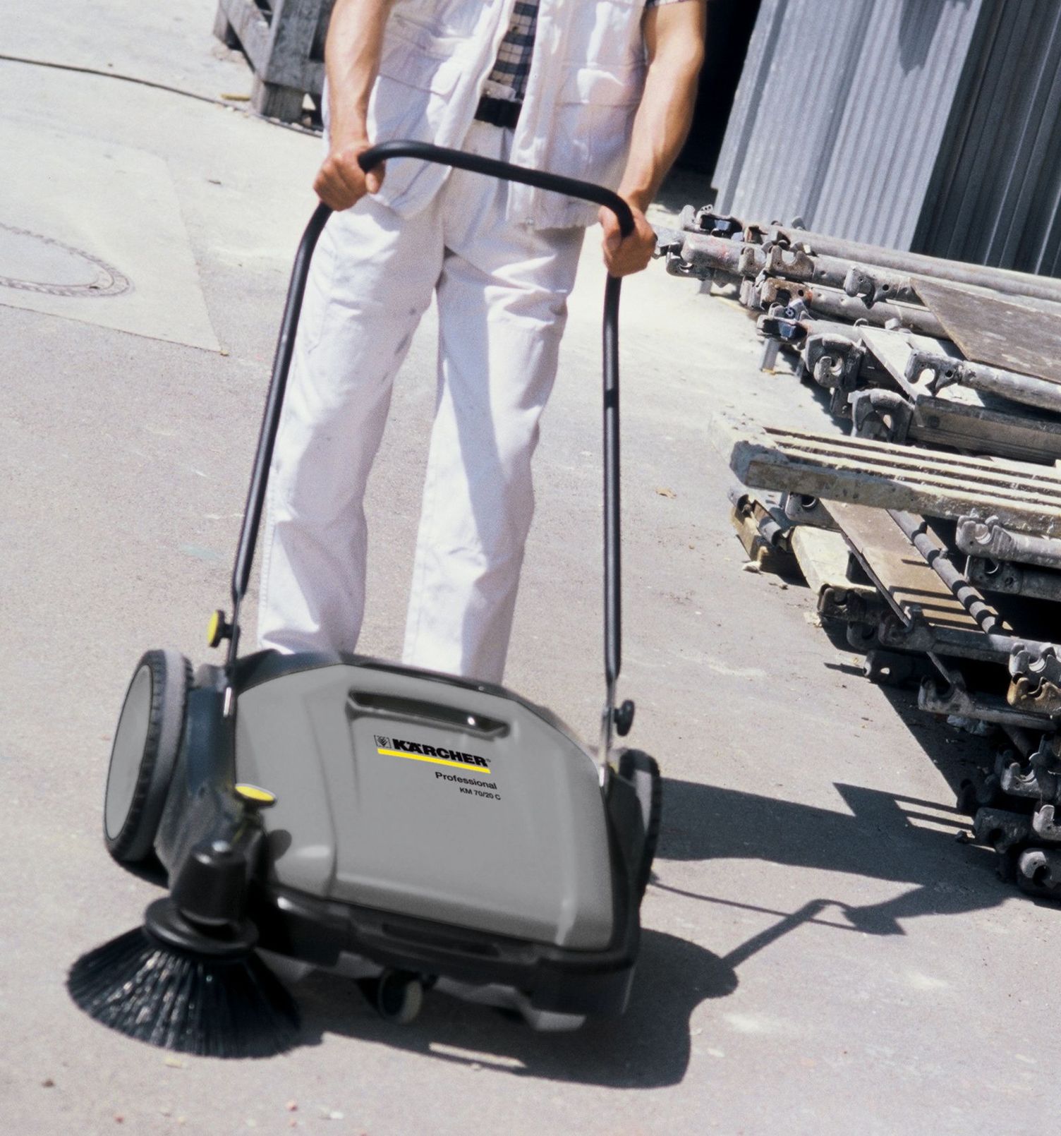 A person uses a vacuum sweeper