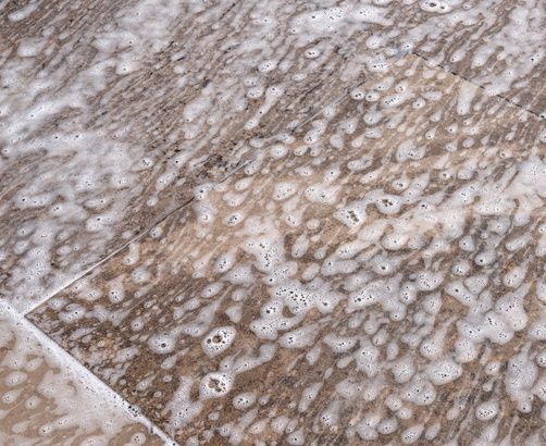 Patio cleaning: emoving stains Detail of foam on stone slabs