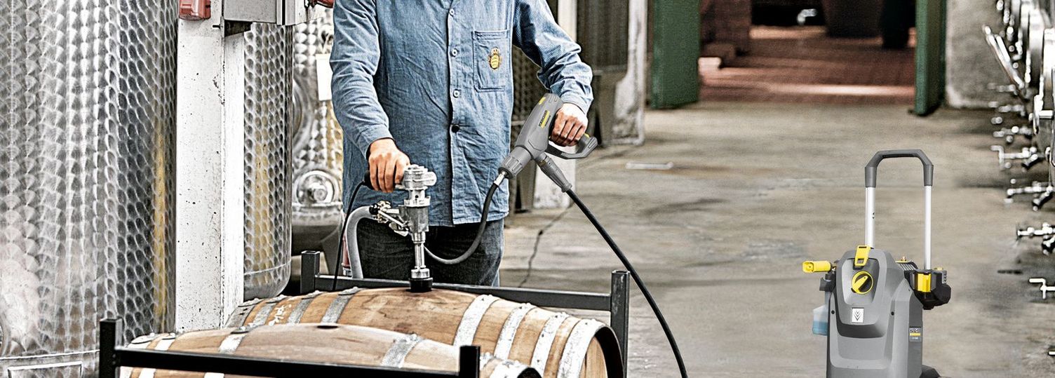 A man is cleaning wine barrels