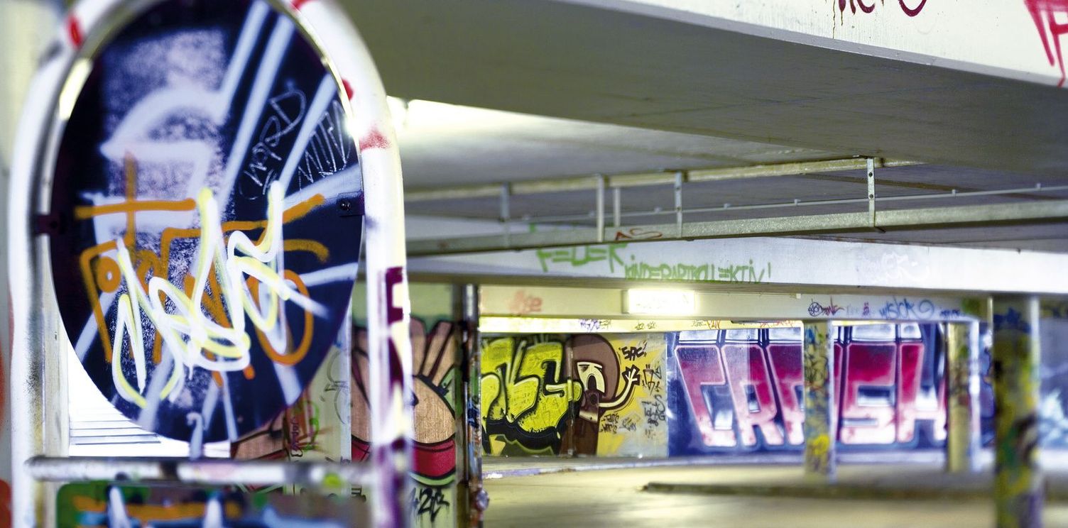 Graffiti on various surfaces in an underground car park