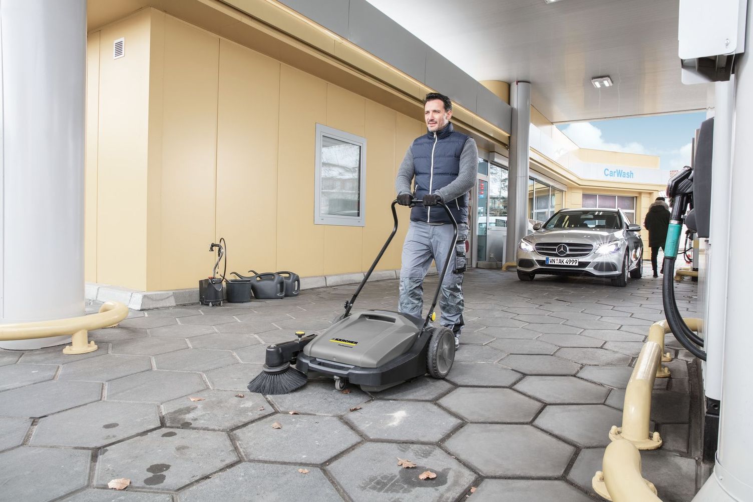 Push sweeper in use on the forecourt Push sweeper in use on the forecourt