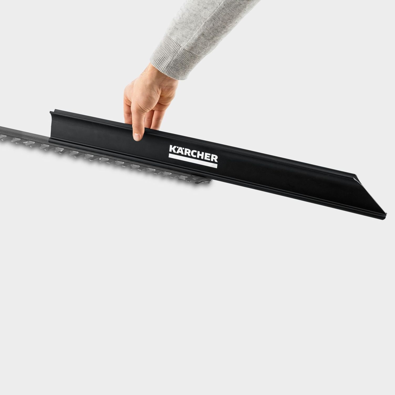 one hand demonstrates the working principle of the hedge broom of the Kärcher battery hedge trimmer