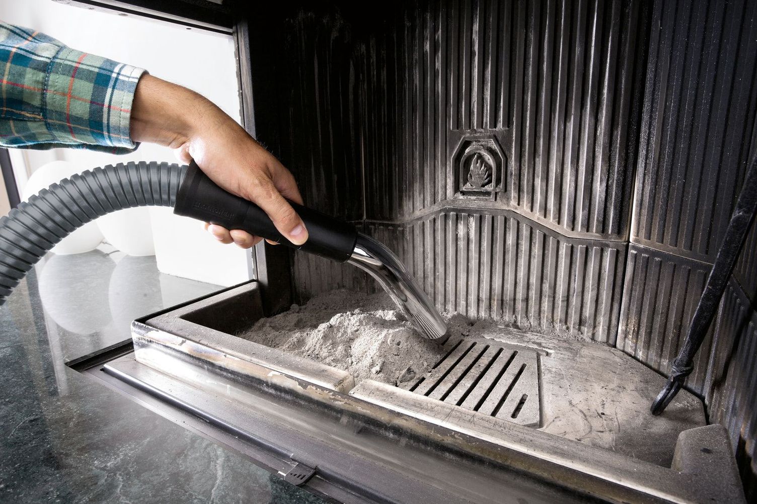 Ash is vacuumed from the fireplace with an ash vacuum cleaner