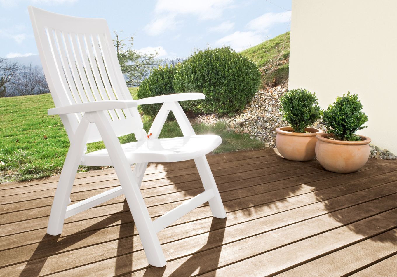 A white plastic chair on a patio