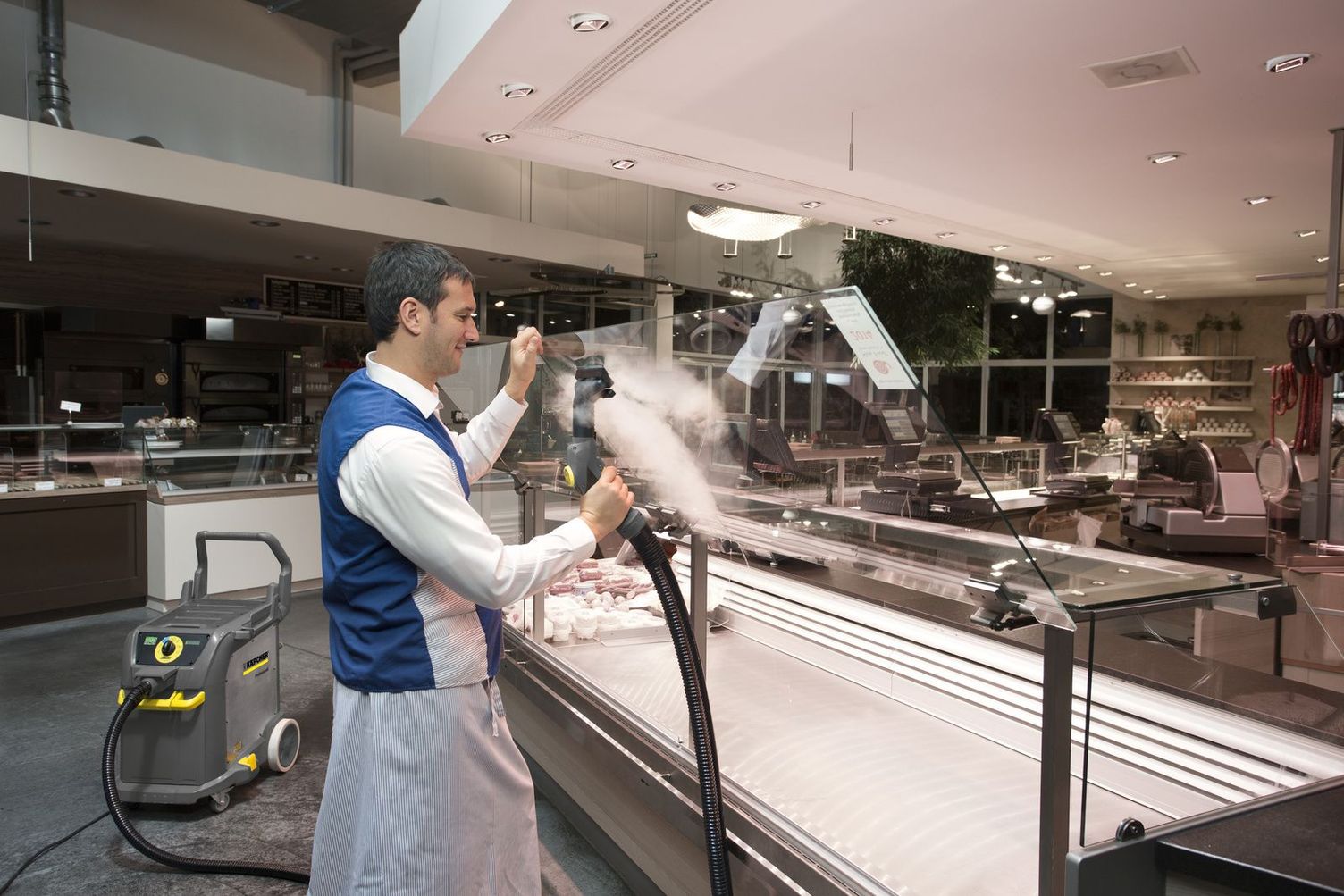 Cleaning shop windows with steam vacuum cleaners