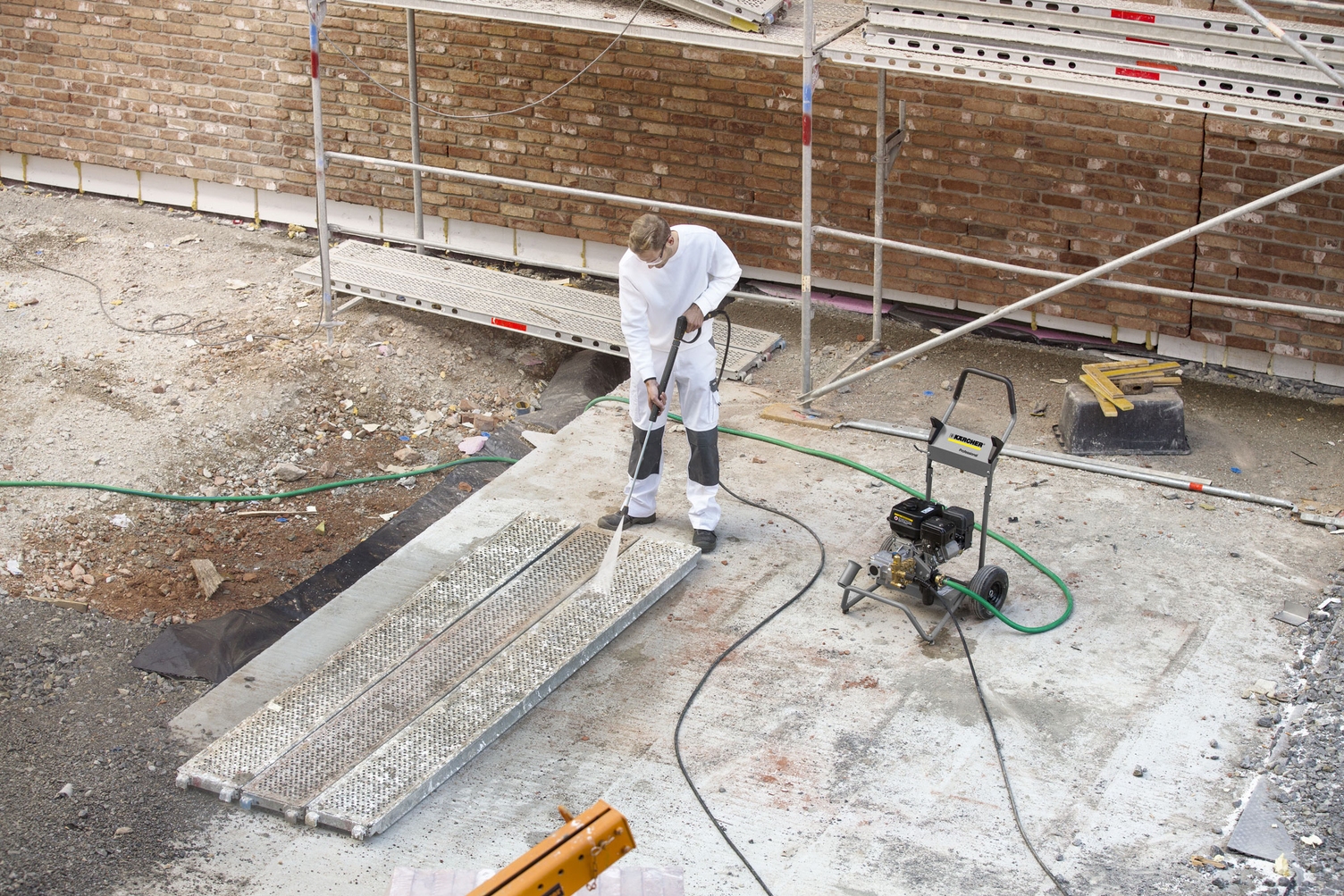 Person cleaning a framework on a construction site