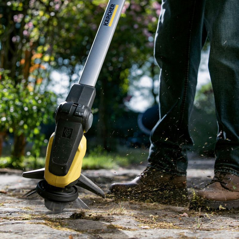 Person removes weeds using the Kärcher battery weed remover WRE