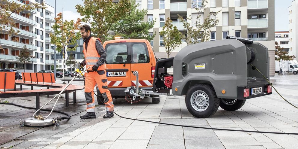 Working with high pressure trailer A person cleans a public place with a Kärcher HDS Trailer