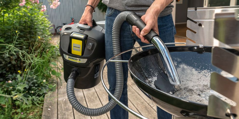 Ash is vacuumed from a grill with an ash vacuum cleaner