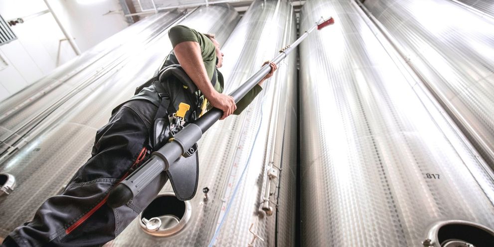 Worm’s-eye view: A man cleans a stainless steel tank