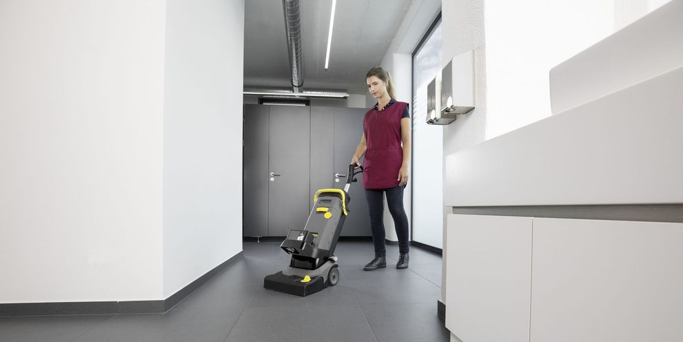 One person cleans the floor of a locker room