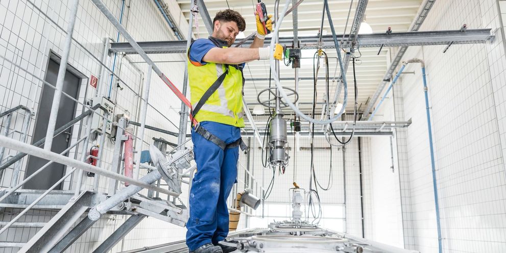 Interior tank cleaning A man standing on and cleaning a silo