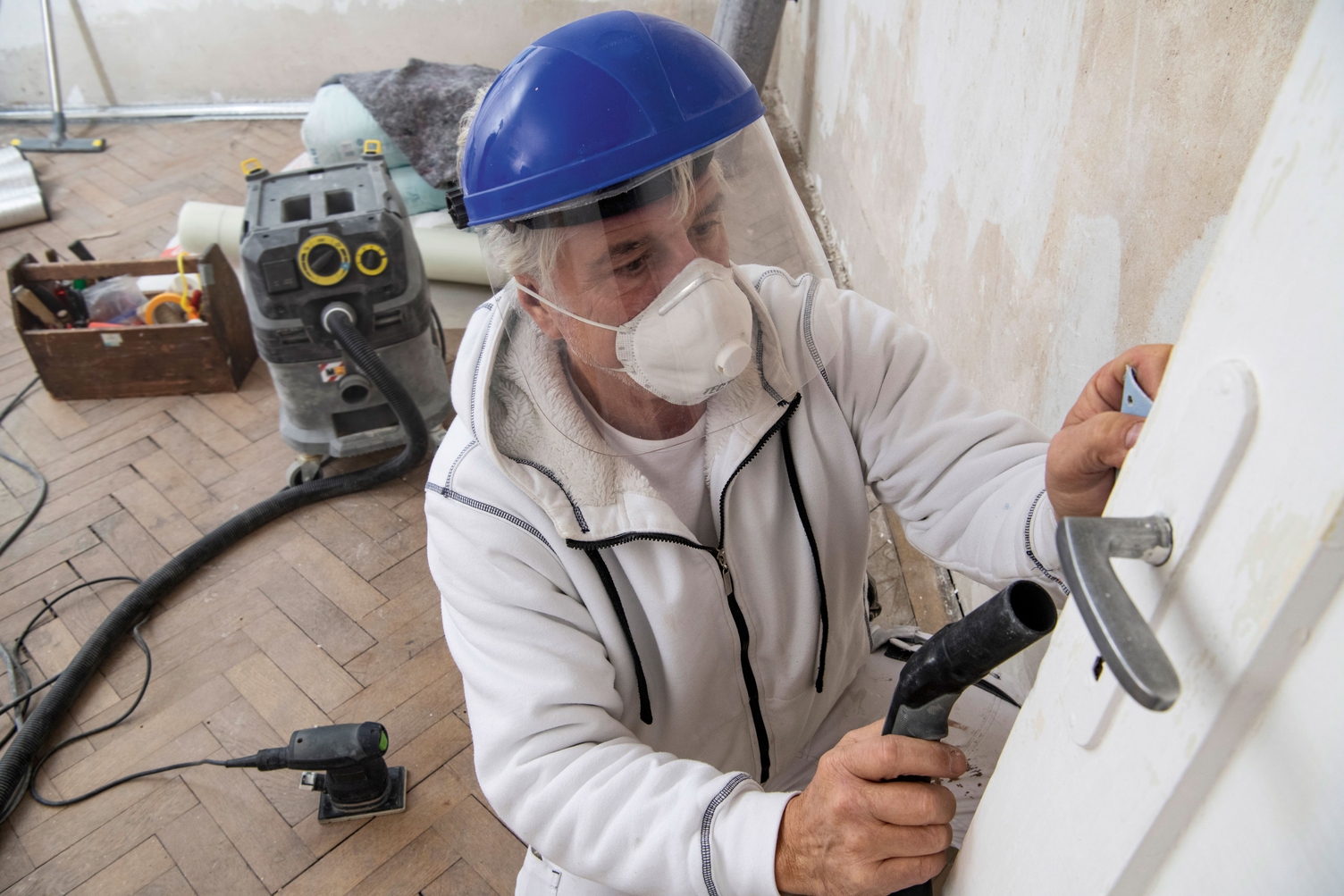 Person vacuuming up dust on a construction site Person vacuuming up dust on a construction site