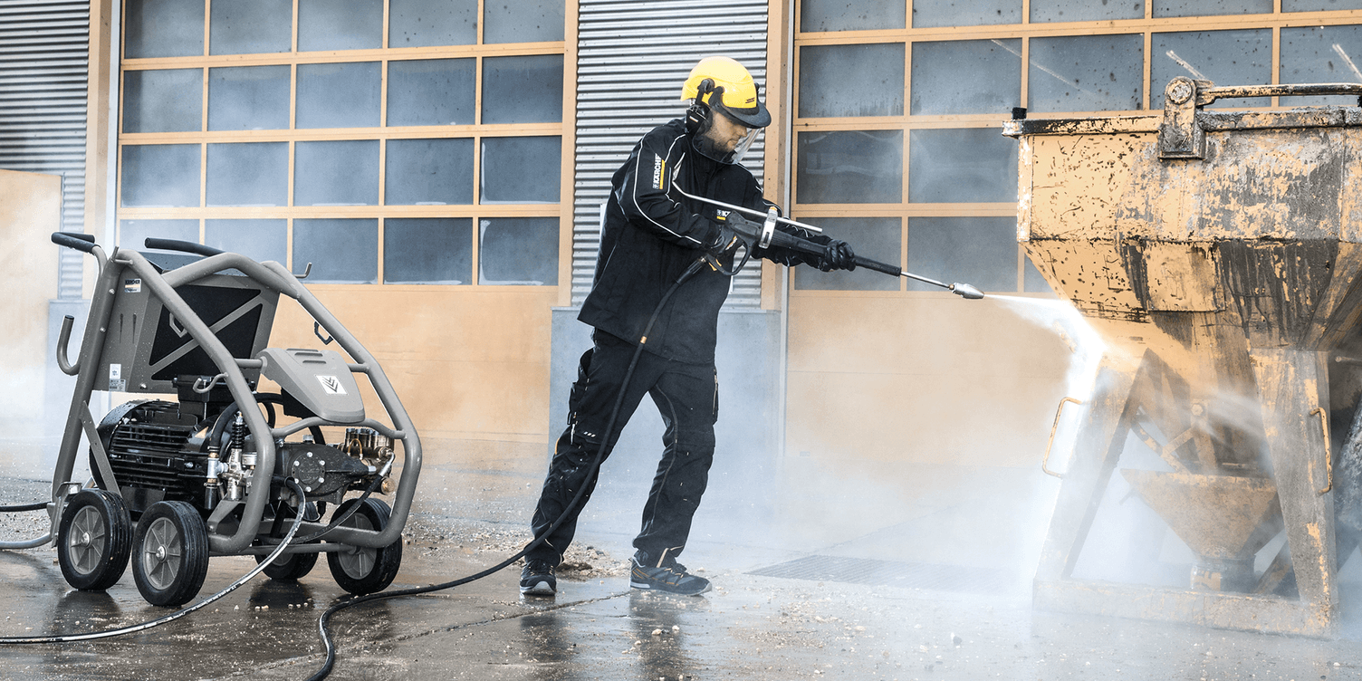 Person cleaning power tools with a high-pressure cleaner Person cleaning power tools with a high-pressure cleaner