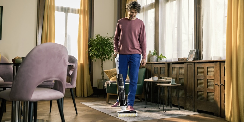 Person cleaning the living room with a Kärcher vacuum mop