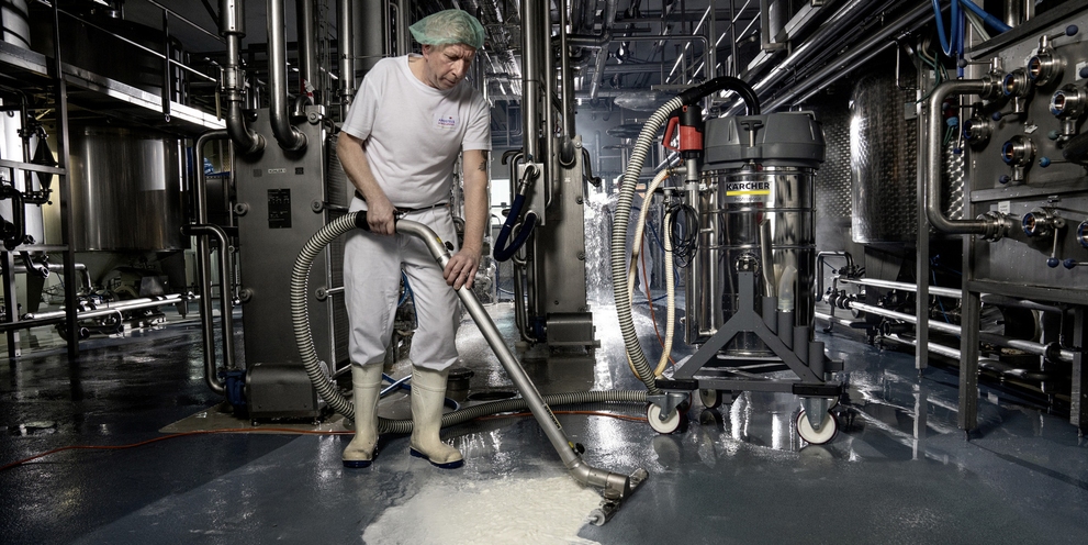 A man vacuums the floor with the industrial vacuum cleaner