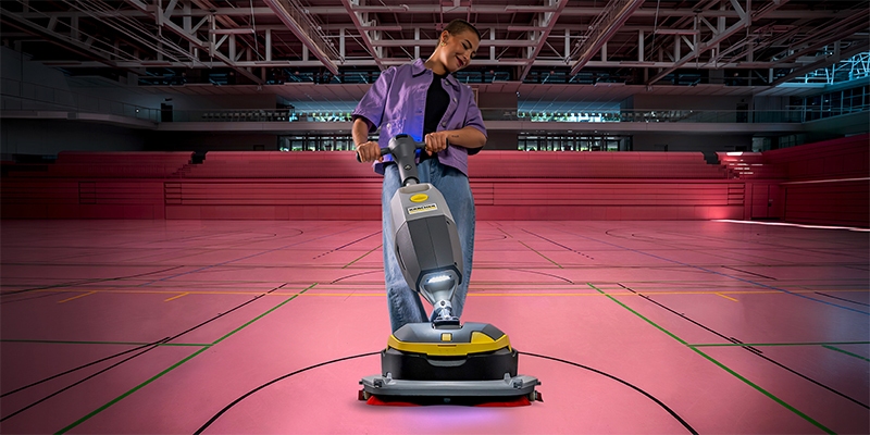 vrouw die vloer in sportzaal aan het schrobben is