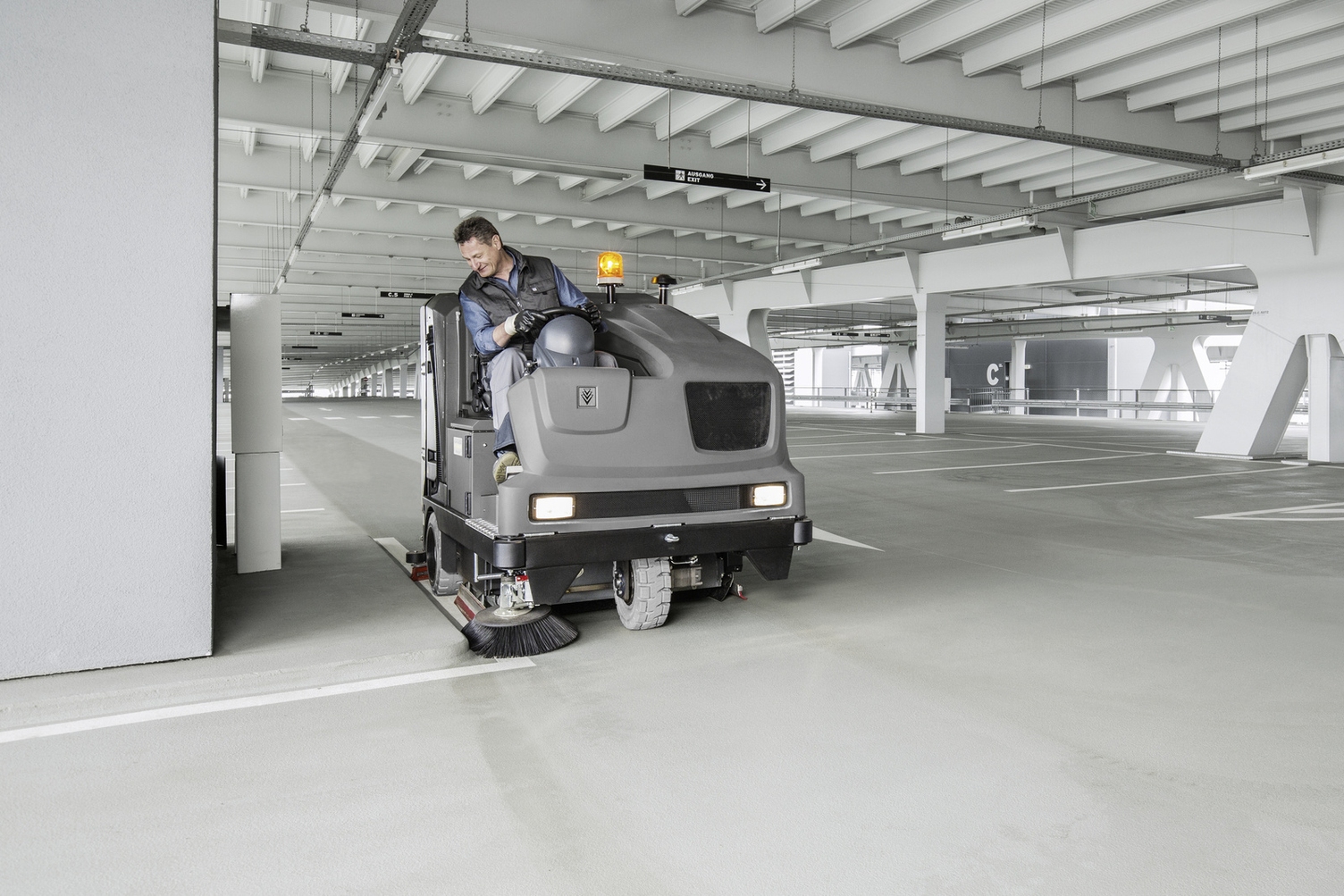 Man is een linoleumvloer aan het schoonmaken met een schrobzuigmachine met snoer.