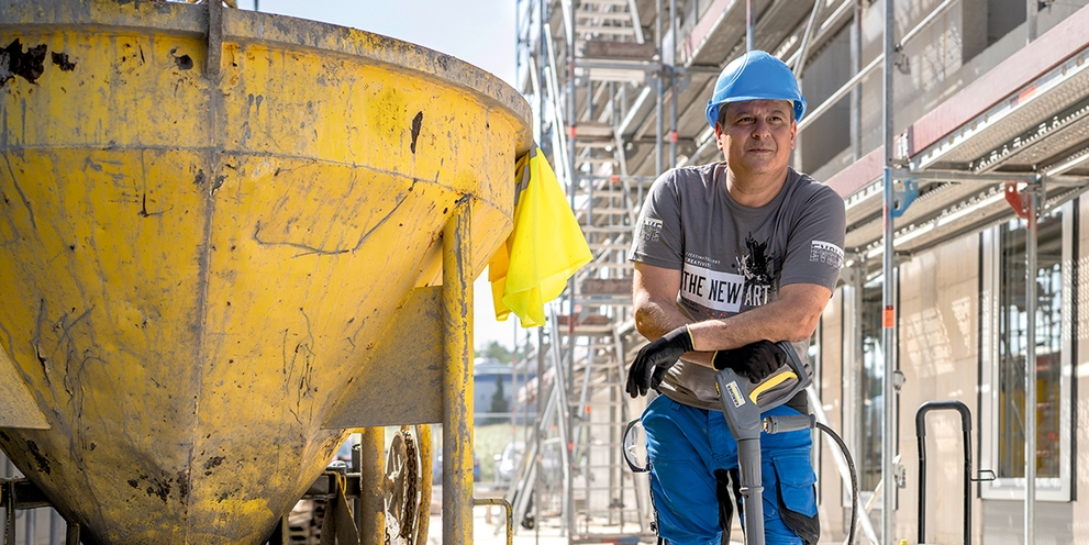 man die betonmolen aan het reinigen is met een hogedrukreininiger