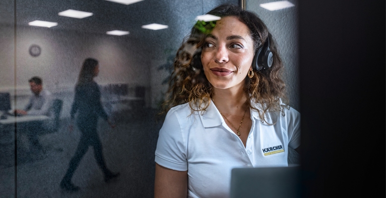 vrouw achter haar bureau die met headset op haar hoofd