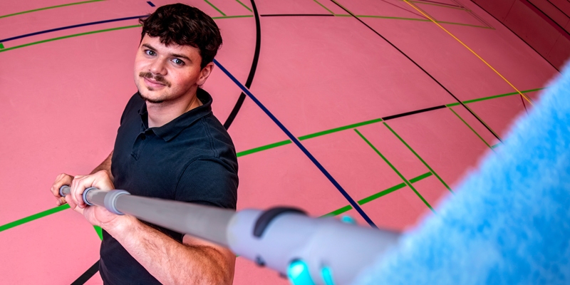 man die in een sportzaal staat 
