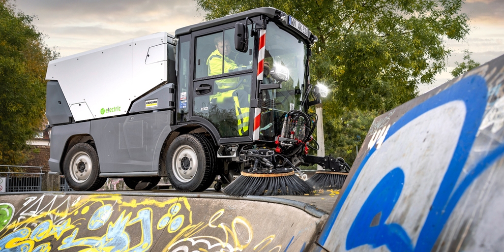 man die in een straatveger zit
