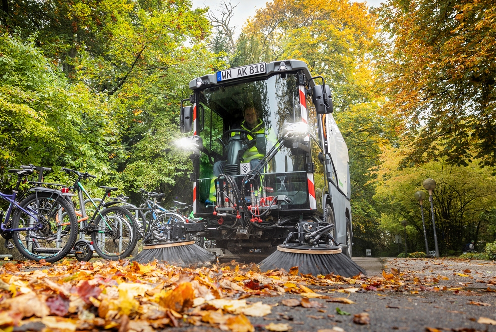 veegmachine die buiten blaadjes aan het opvegen is