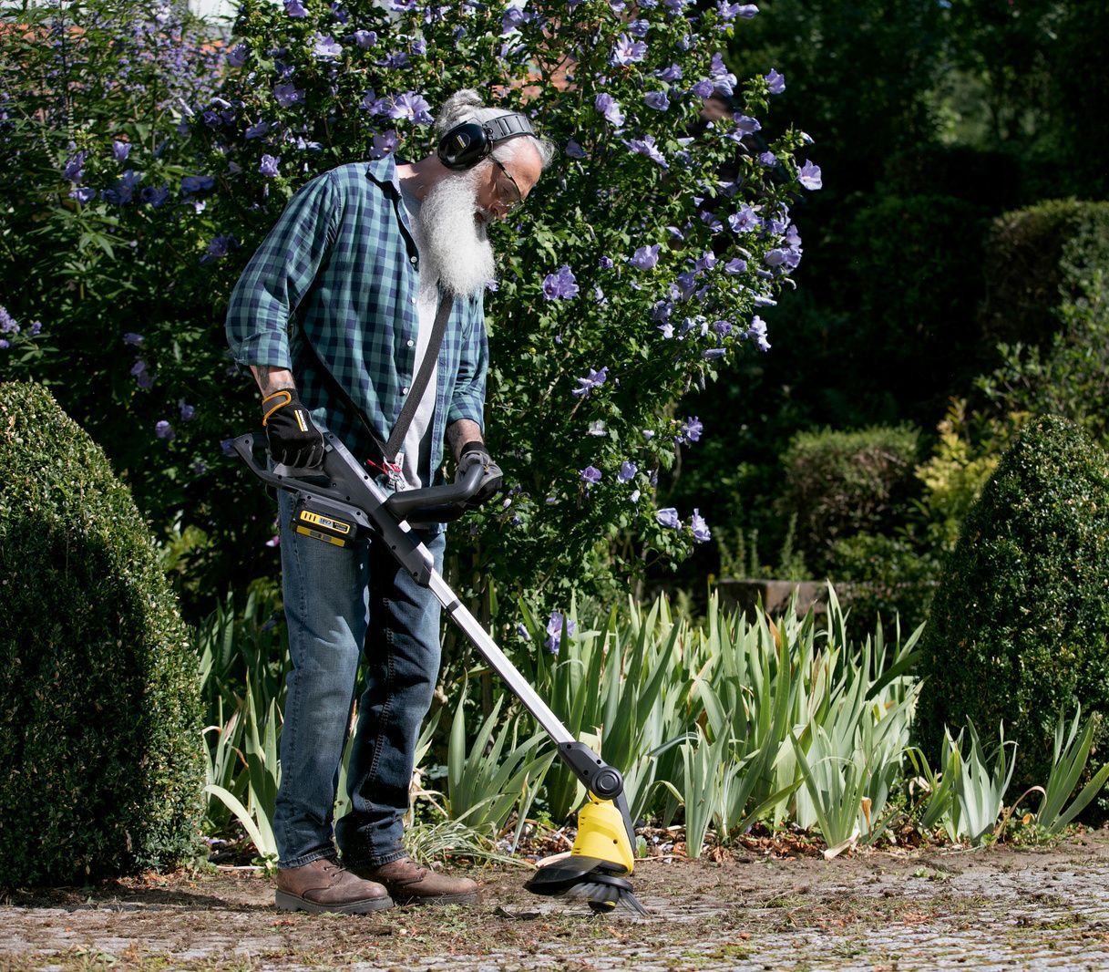 A man cleans a patio with his Kärcher weed remover