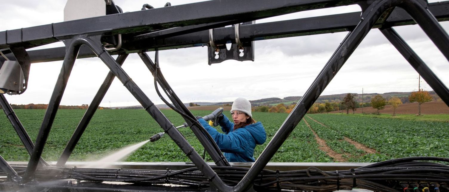 Field sprayer external cleaning with a high-pressure washer