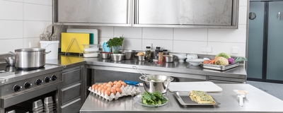 A large kitchen with various foods and different kitchen utensils