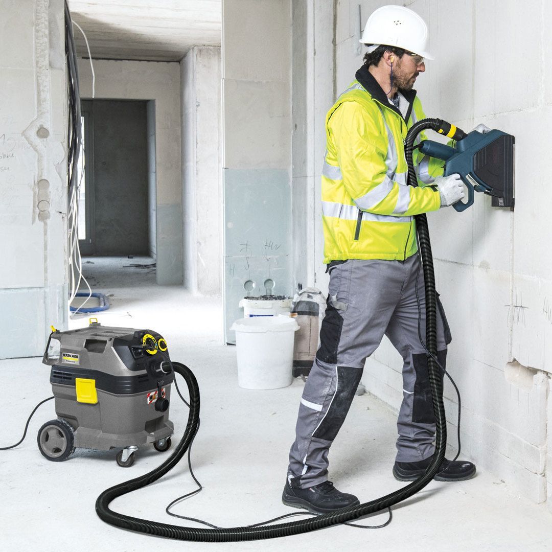 Person uses Kärcher fine dust vacuum cleaner with filter cleaning on construction site